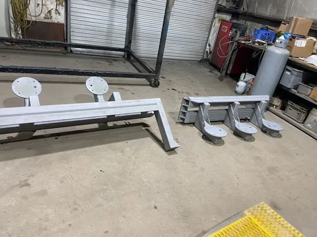 Multiple frame components with white primer staged for coating