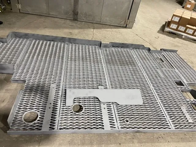 Large gray powder coated mesh panel assemblies indoors