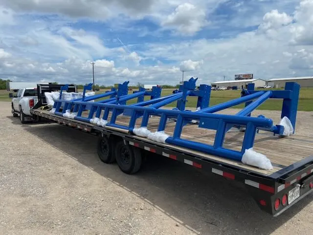 Multiple blue coated frames loaded on flatbed trailer for delivery